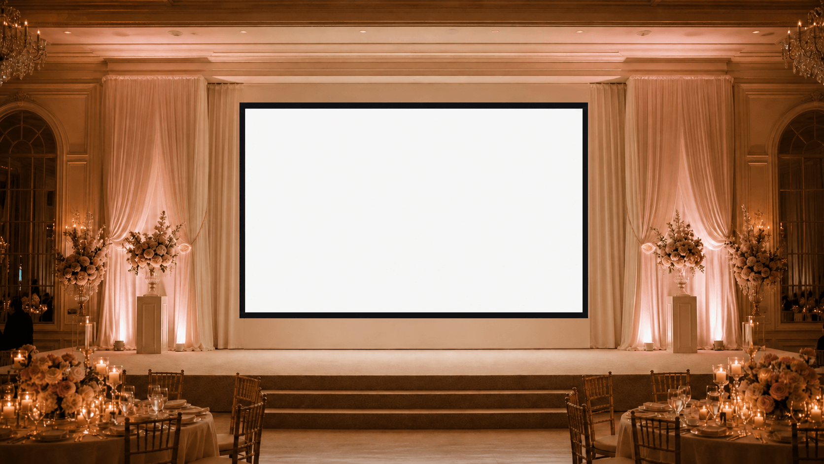 An elegant candlelit wedding reception hall with a large projection screen on stage